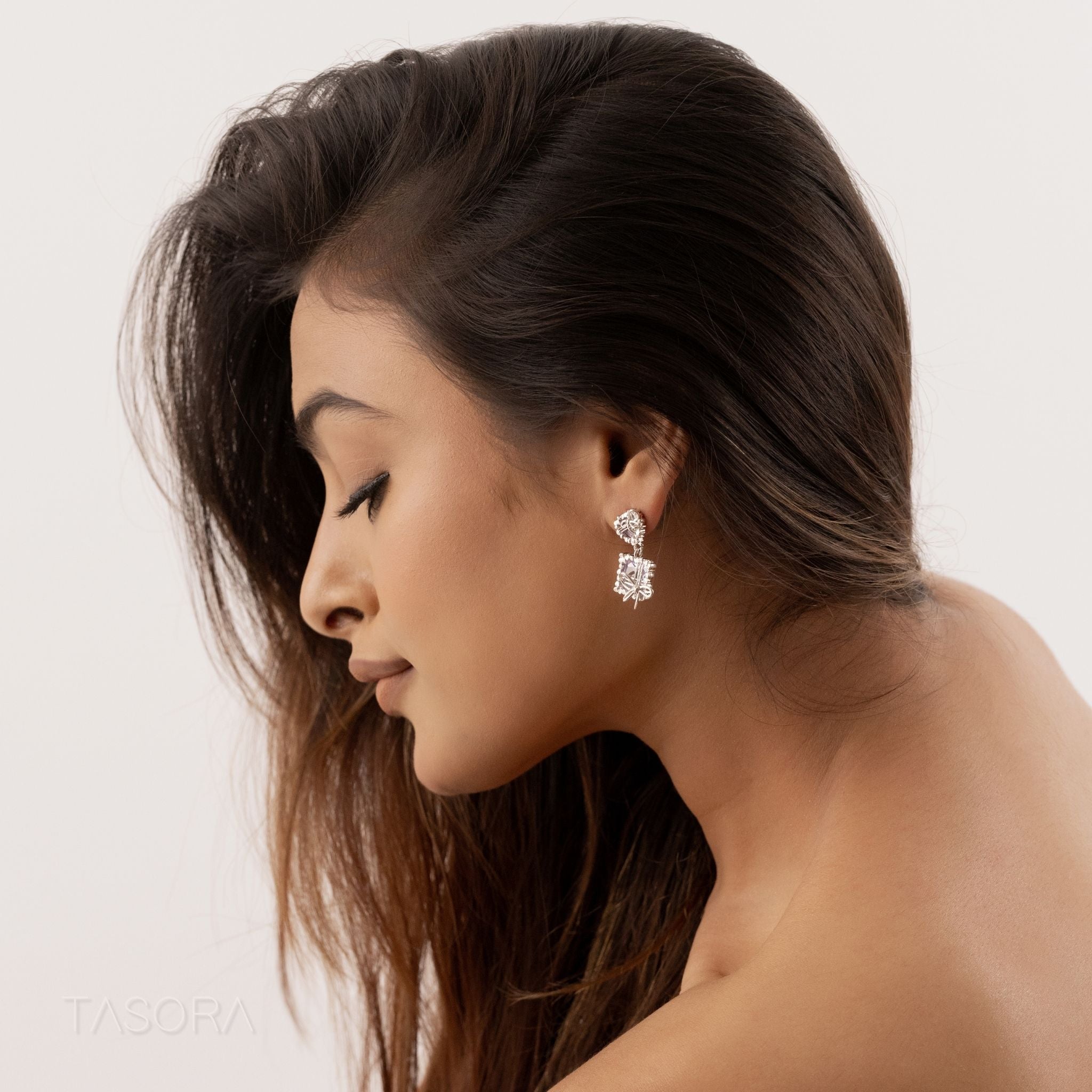 Woman wearing a Bow Belle earring by TASORA on a neutral background 