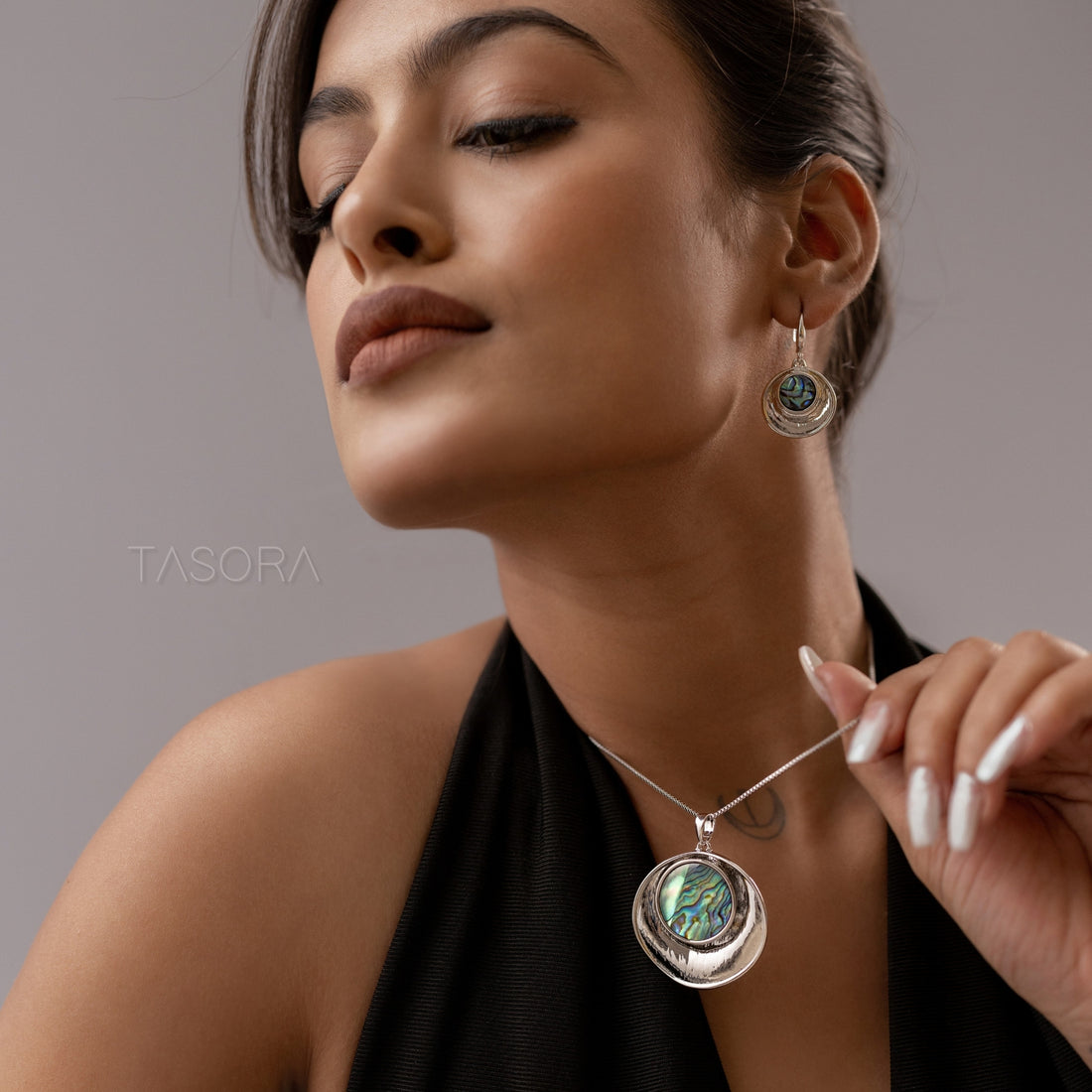 Coral Glow Jewelry set with pendants and earrings on a neutral background, featuring the brand 'TASORA'. The jewellery set is available in golden and silver color. It features a big abalone shell in the center.