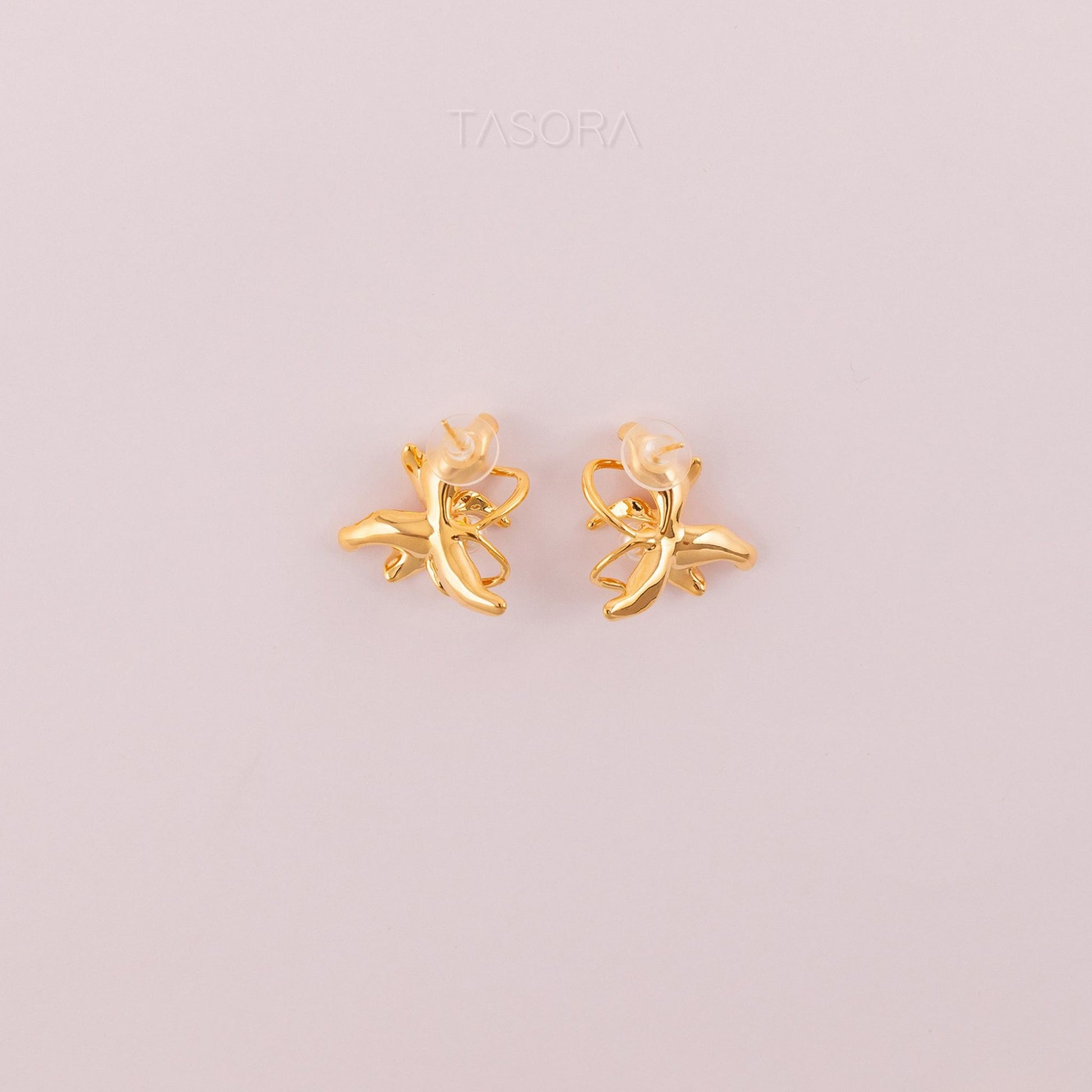 Back side of Dancing Flamenco Golden earrings on a light pink background with 'TASORA' branding.