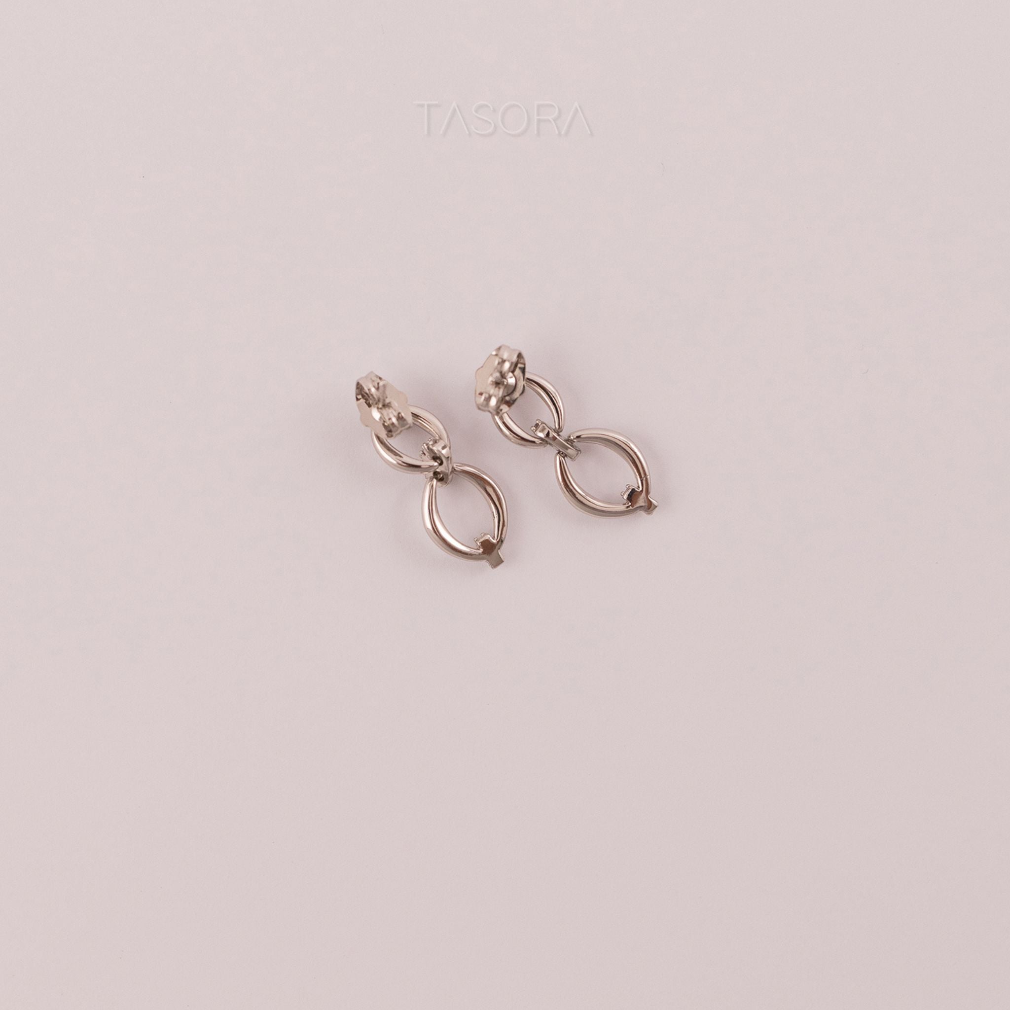 Back Side of Elior Silver earrings on a light natural background with 'TASORA' branding.