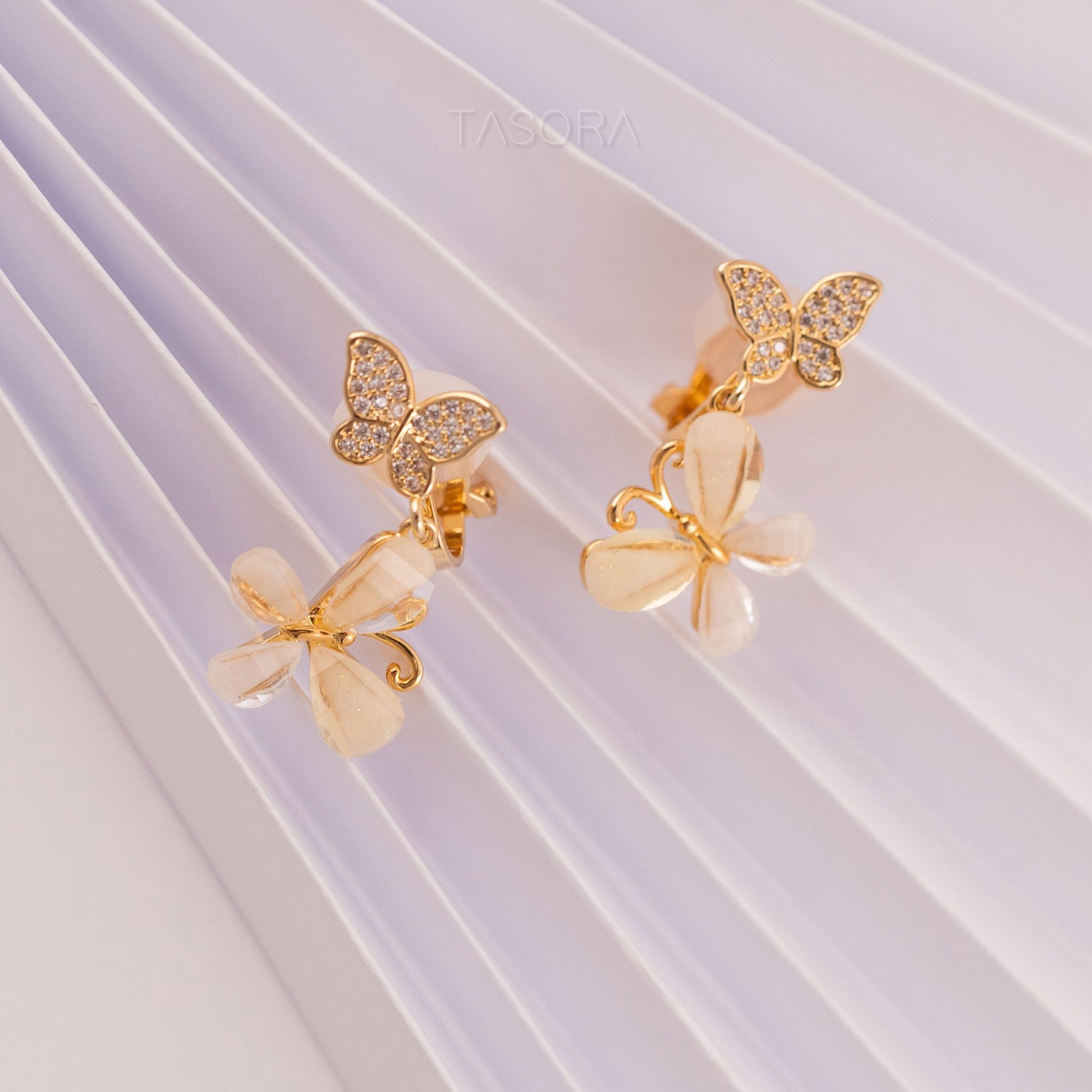Golden butterfly shape Flutter Petal earrings on a white background with TASORA branding
