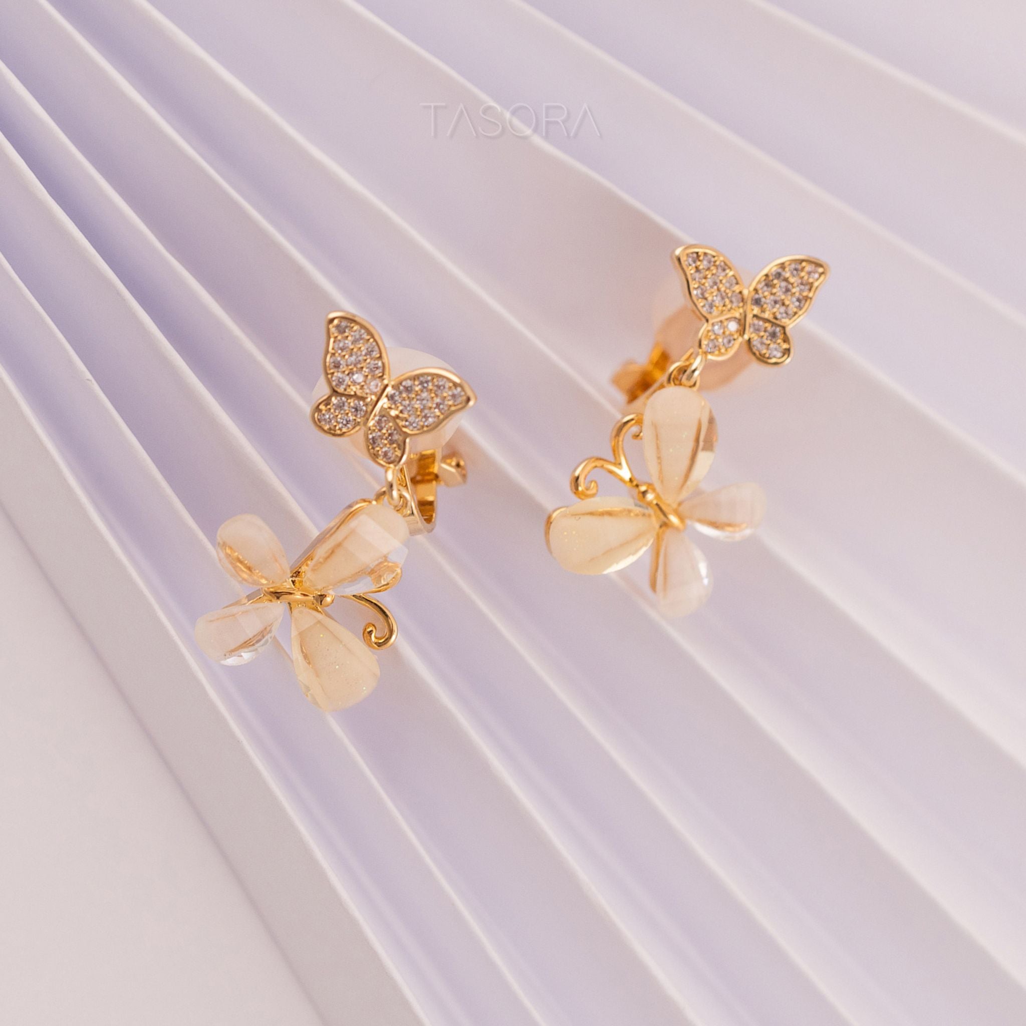 Golden butterfly shape Flutter Petal earrings on a white background with TASORA branding