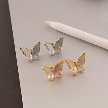 Butterfly-shaped Flutter wings earrings in gold and silver on a light gray background with 'TASORA' branding.