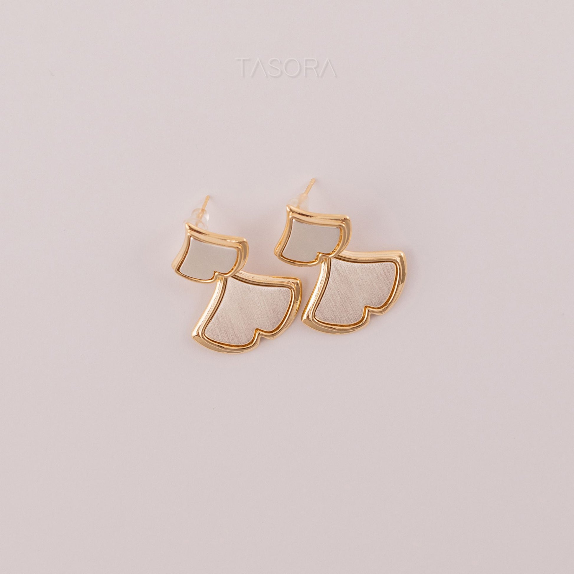 Gold and white Golden Glint earrings on a light natural background