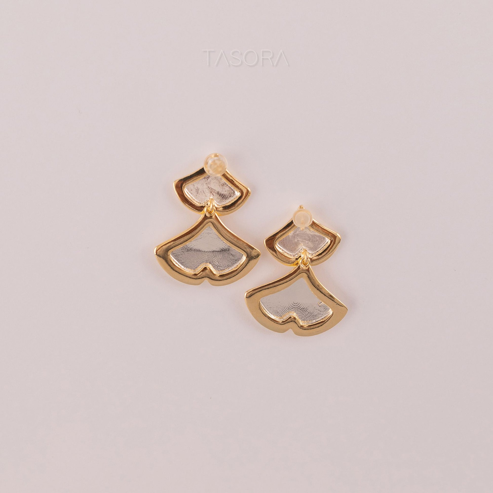 Back side of Golden Glint earrings with a textured design on a light background