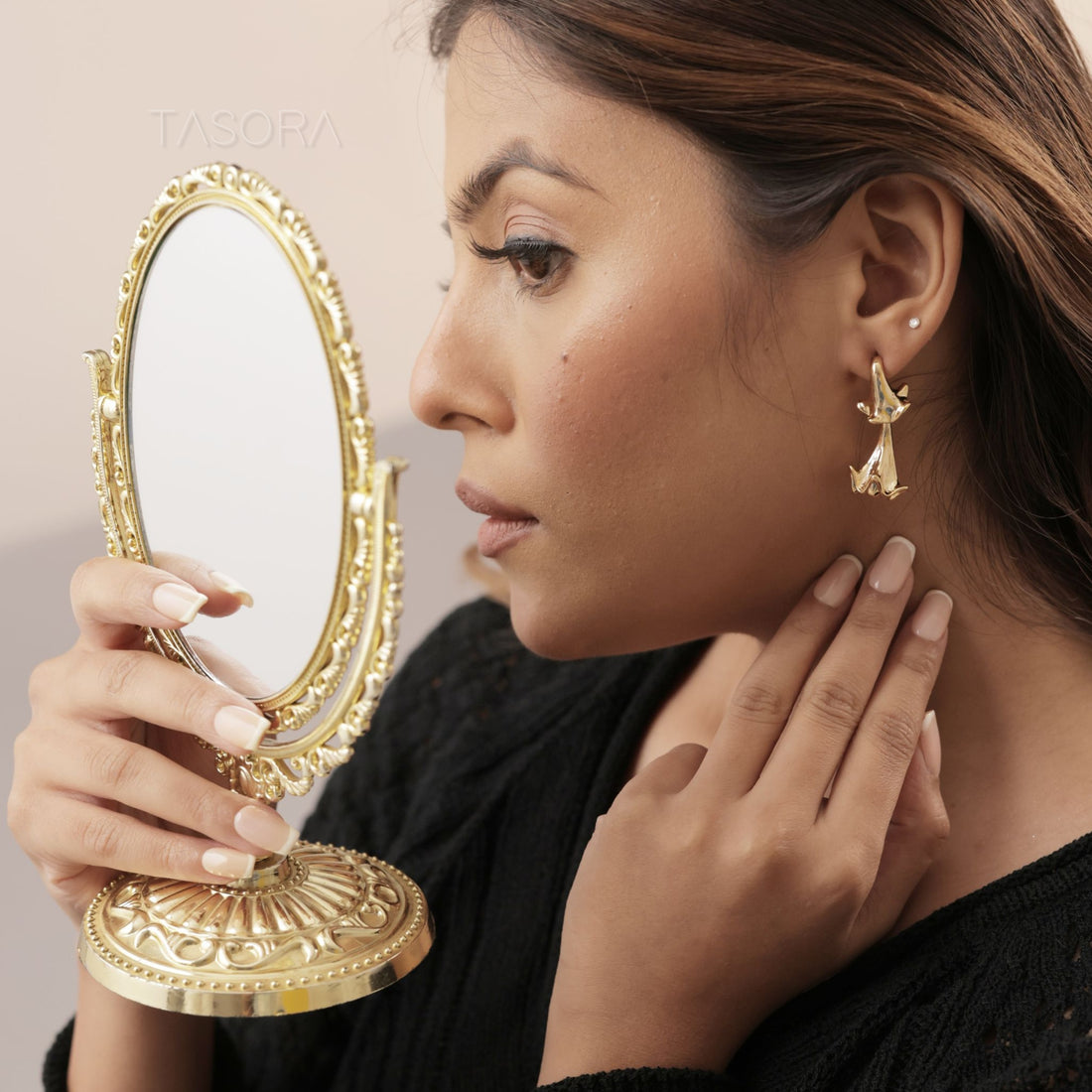 Pair of silver and golden Hibelle Drop earrings on a beige surface with 'TASORA' branding.