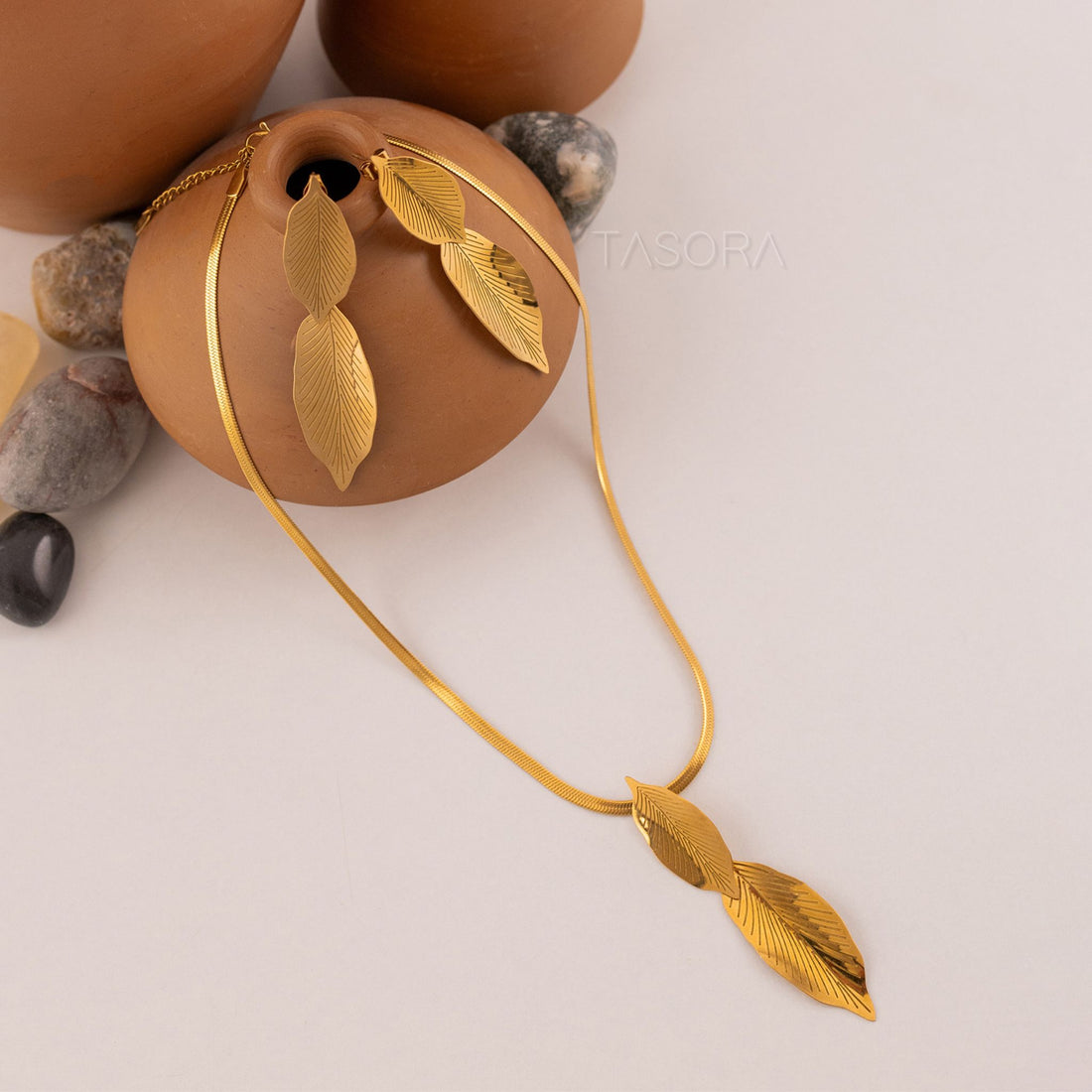 Golden Lustre Leaf necklace of TASORA brand with leaf designs on a neutral background