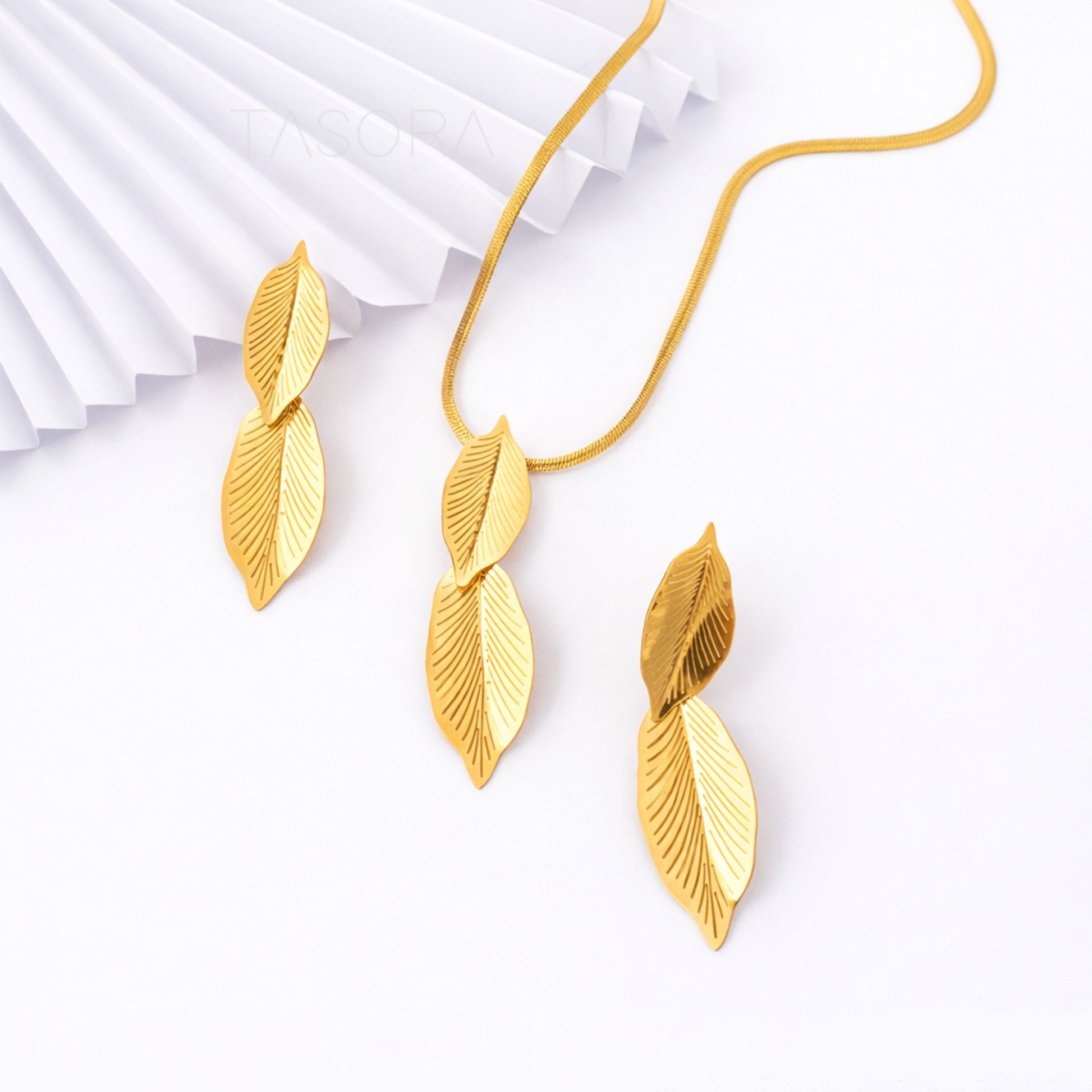 Gold leaf-shaped necklace on a white background branding TASORA