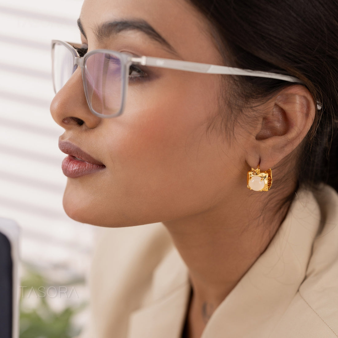 Square-Shaped Opaline Dot earrings in golden and silver on a dark surface with a phone in the background with TASORA branding.
