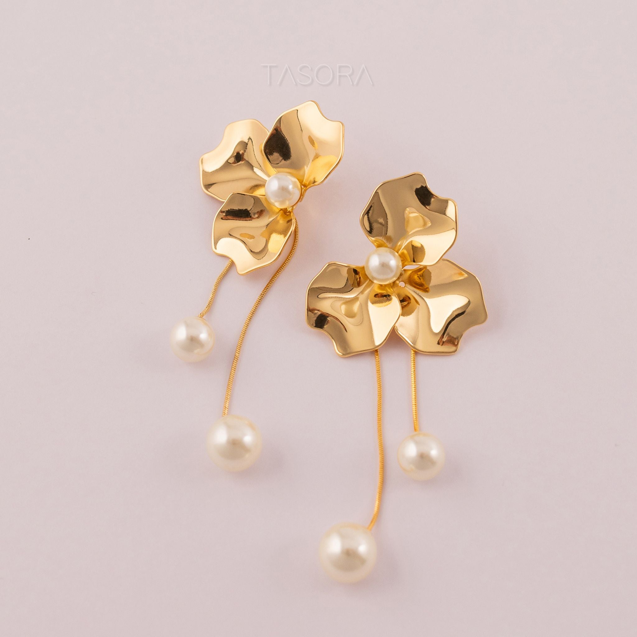 Golden floral with pearl accents Orchid Pearls earrings on a light pink background with TASORA branding