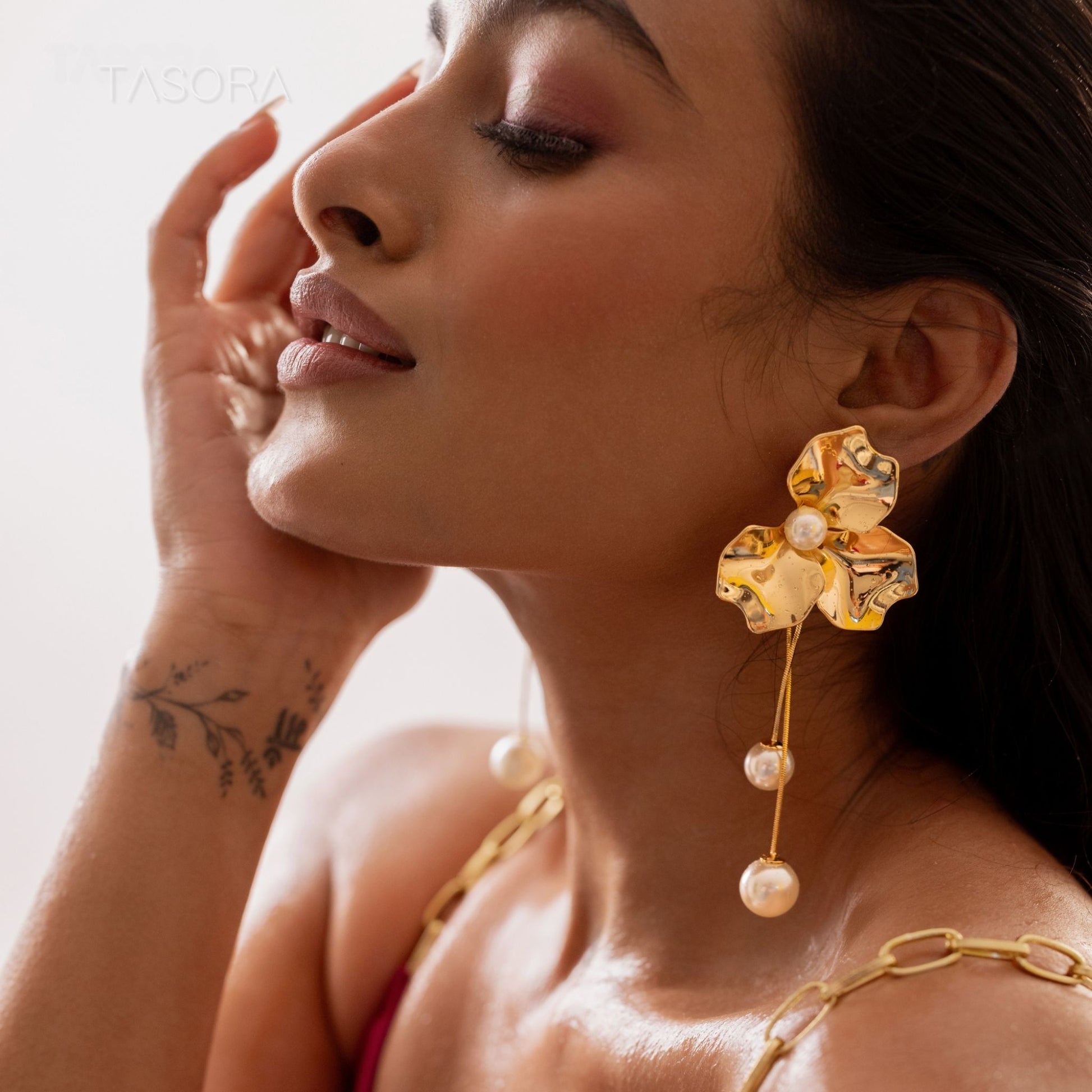 Woman wearing Orchid Pearls earrings Of TASORA brand with a blurred background