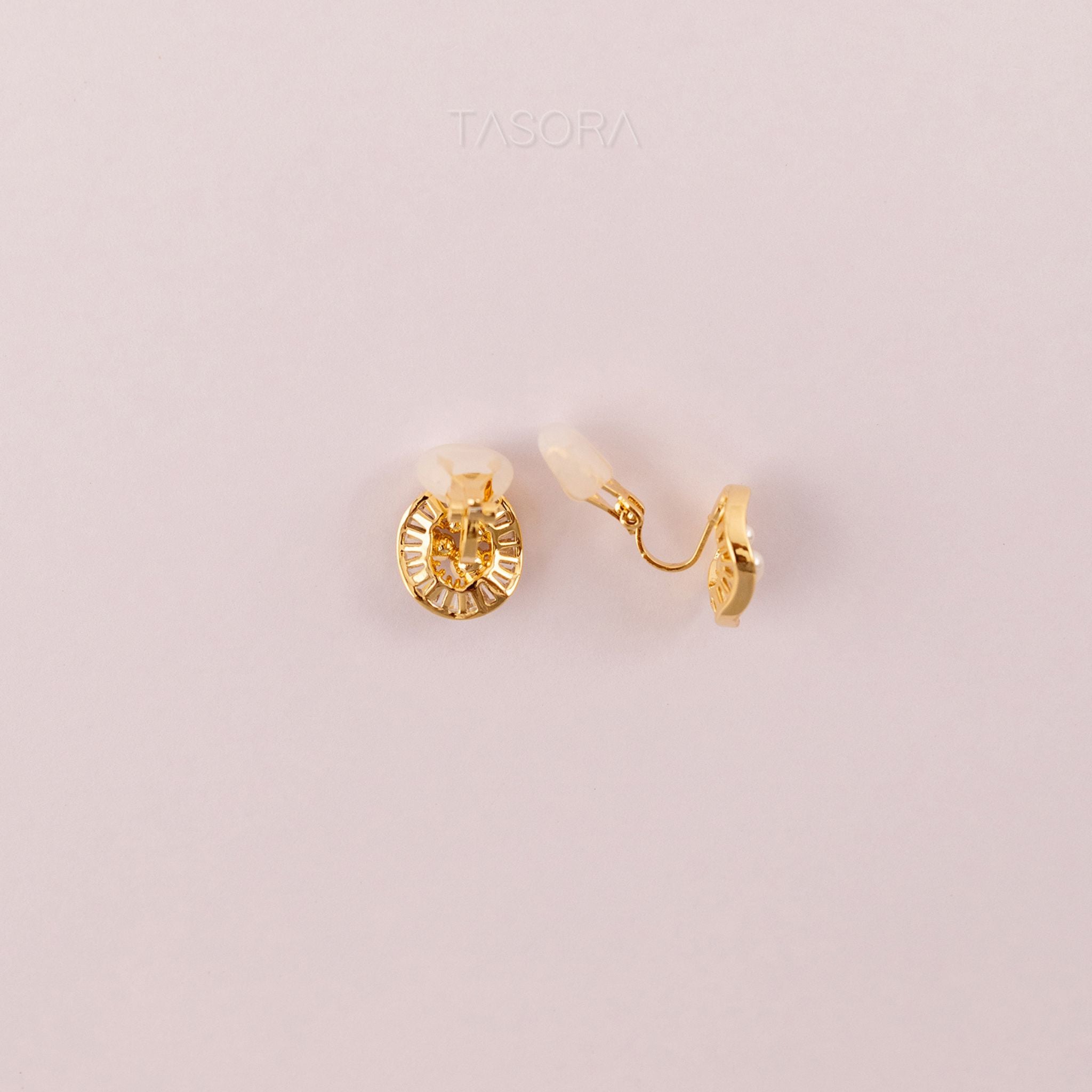 Back side of Oyster Muse Golden earrings on a light pink background with 'TASORA' branding.