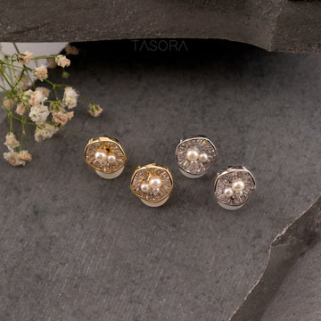 Gold and silver Oyster Muse earrings with pearls on a dark stone surface, TASORA brand visible.