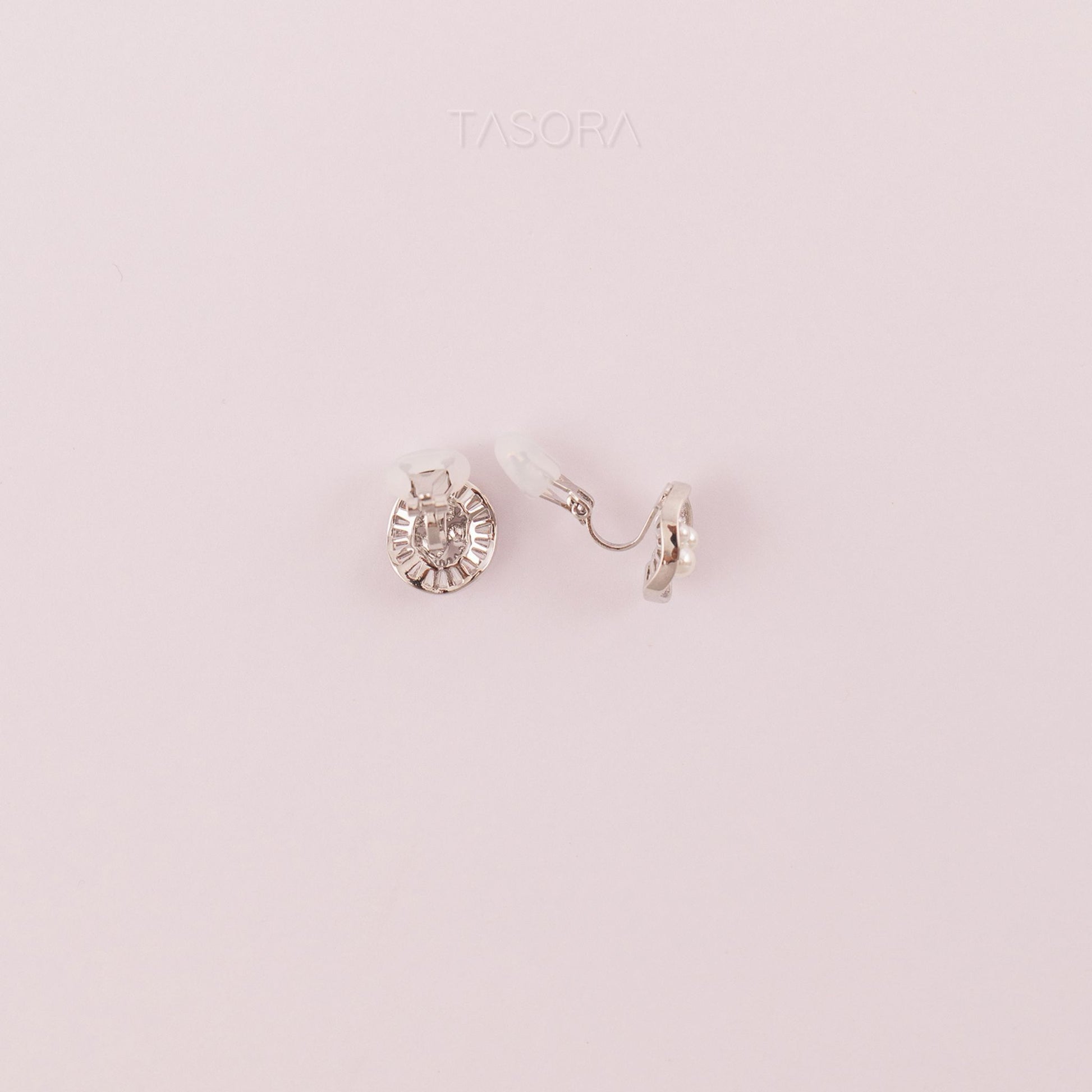 Back side of Oyster Muse Silver earrings on a light pink background, featuring the brand 'TASORA'.