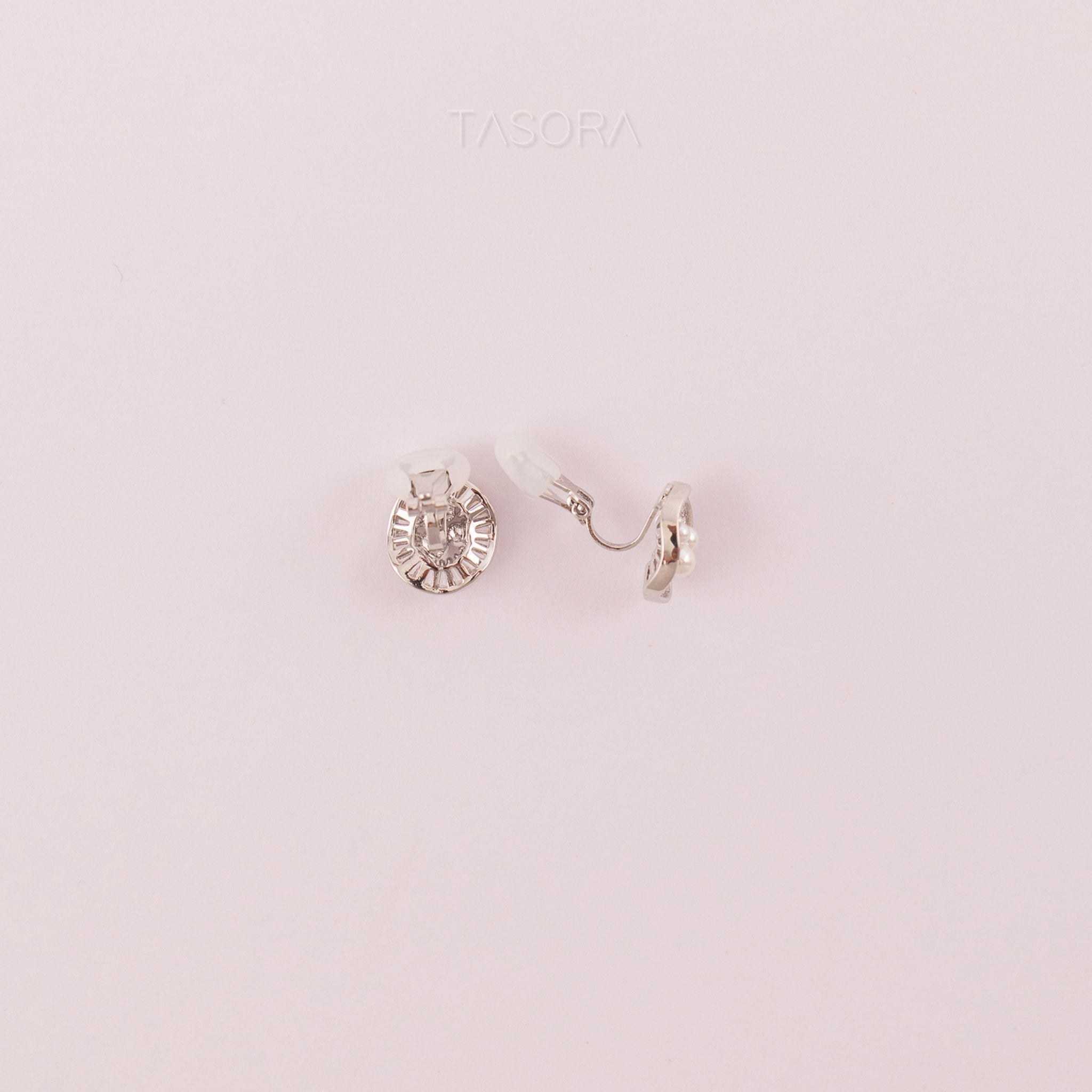 Back side of Oyster Muse Silver earrings on a light pink background, featuring the brand 'TASORA'.
