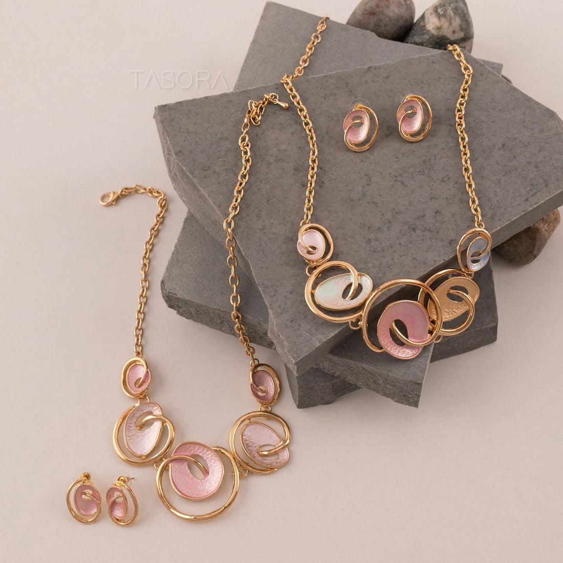 Pastel Swirl Jewelry set with Blush Rose and Saxe Blue colour circular designs on a stone surface with TASORA brand