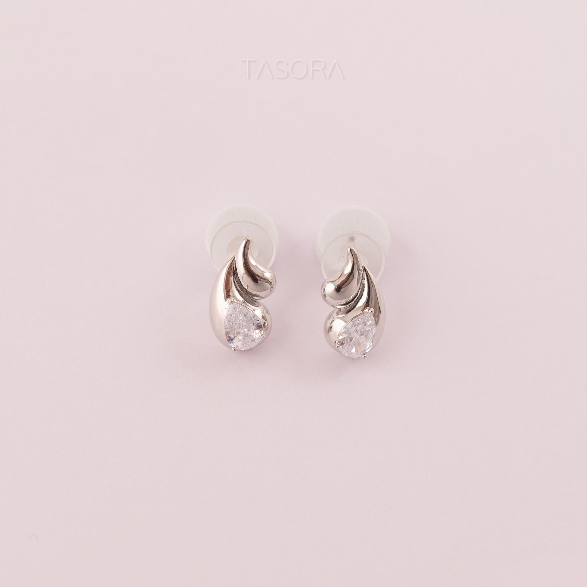 Rain Drop Silver earrings with clear stones on a light natural background, branded 'TASORA'.