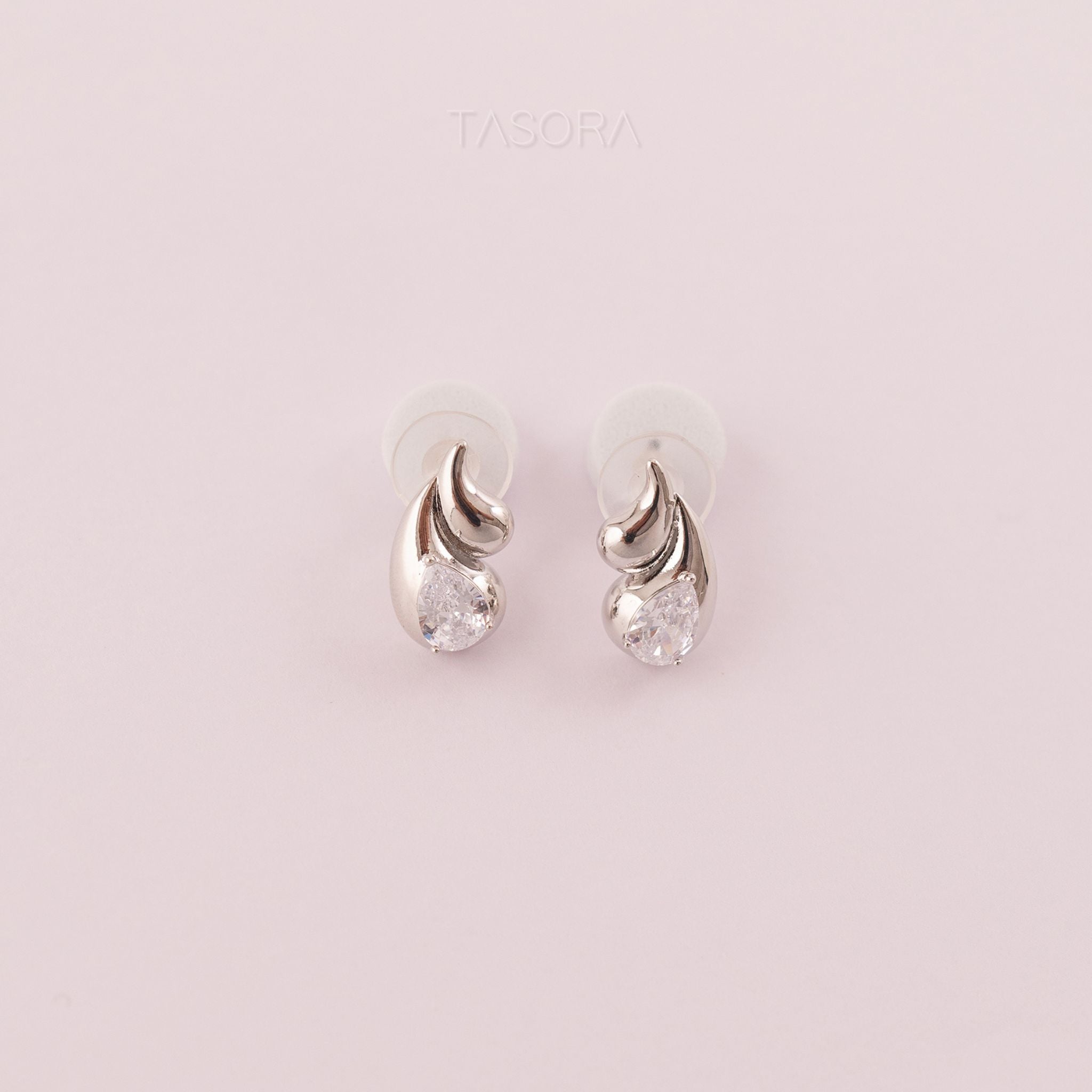 Rain Drop Silver earrings with clear stones on a light natural background, branded 'TASORA'.