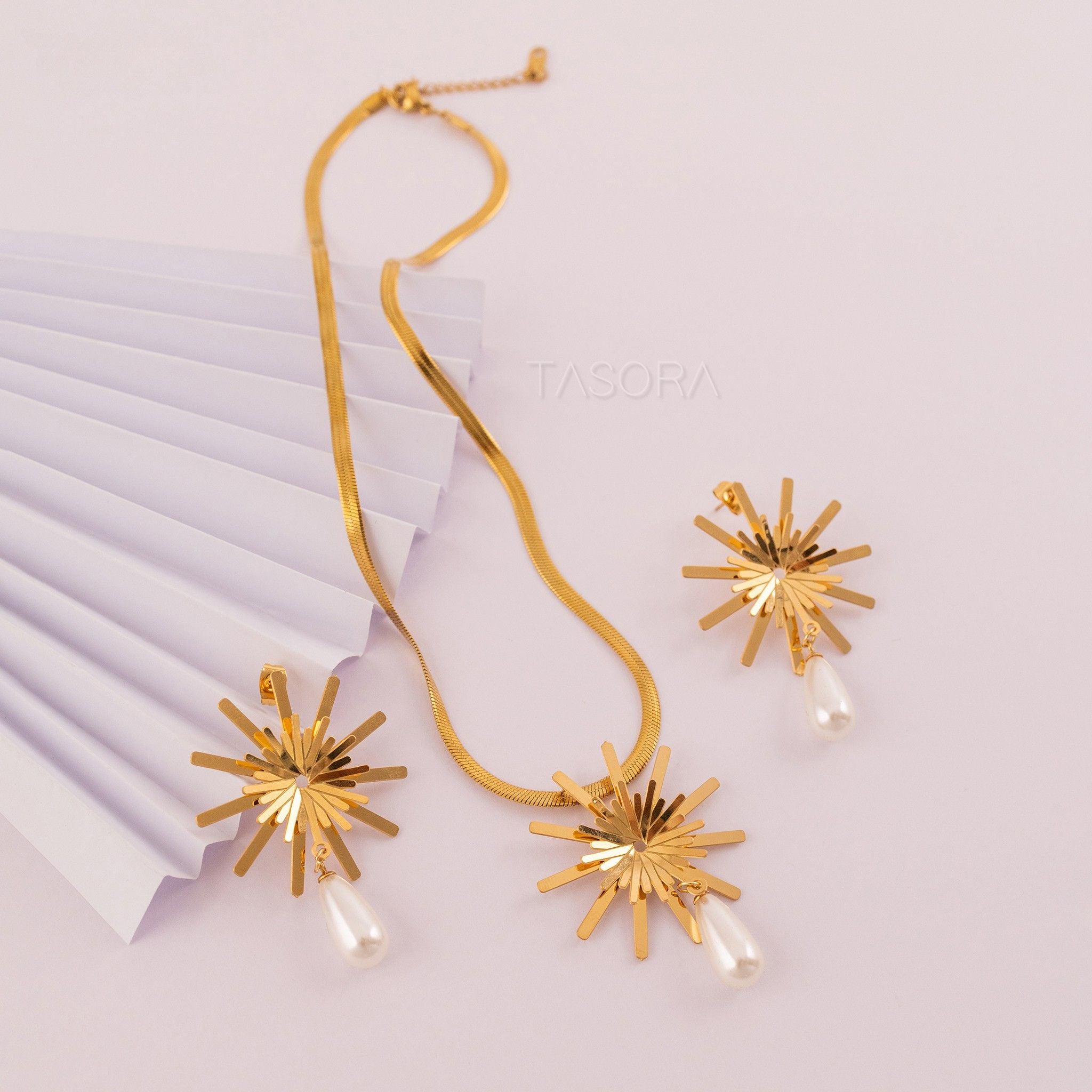 Golden Solara Bloom necklace and earrings by TASORA with starburst design on a light background