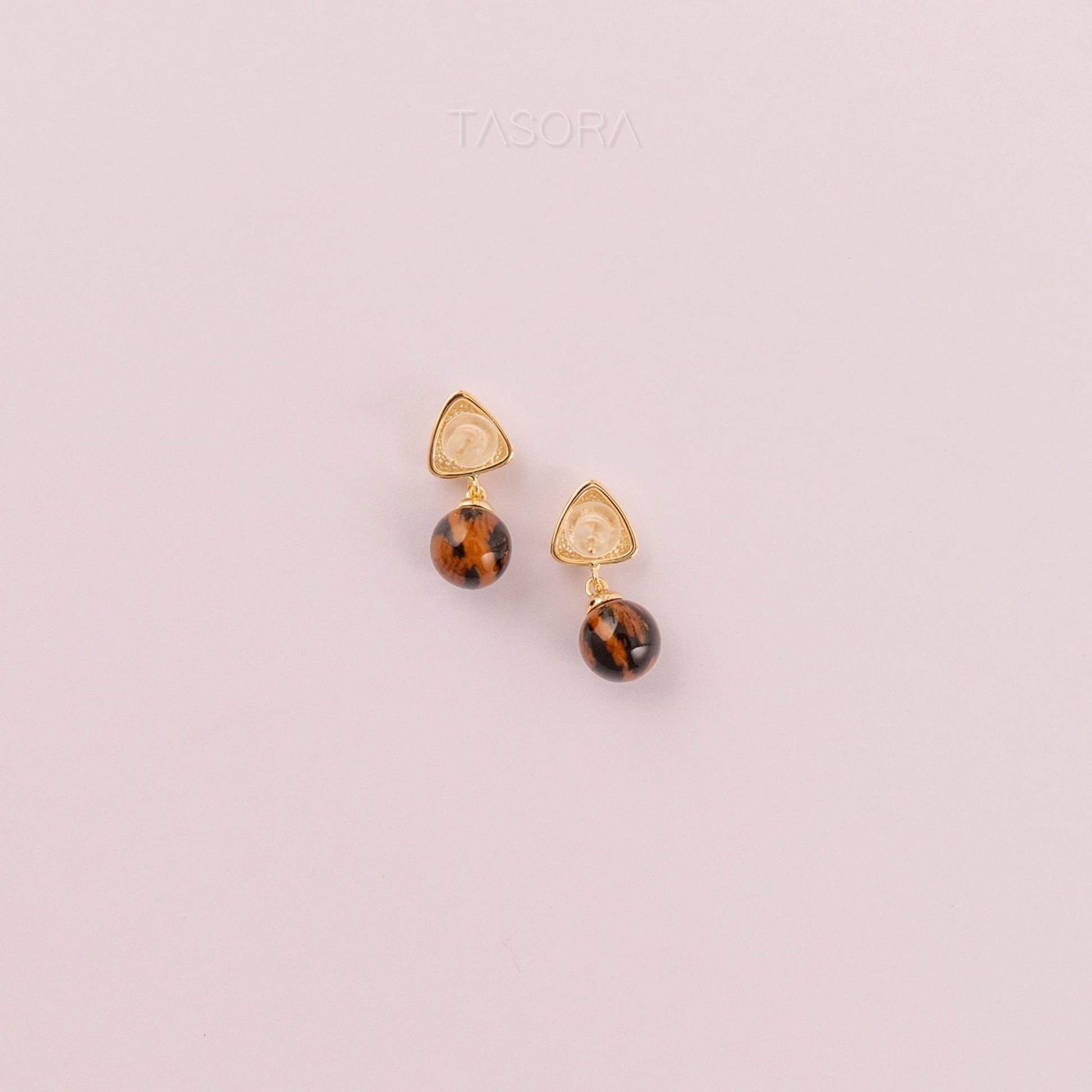 Back side of Sona Halo Earrings tortoiseshell shape on a light pink background with 'TASORA' branding.
