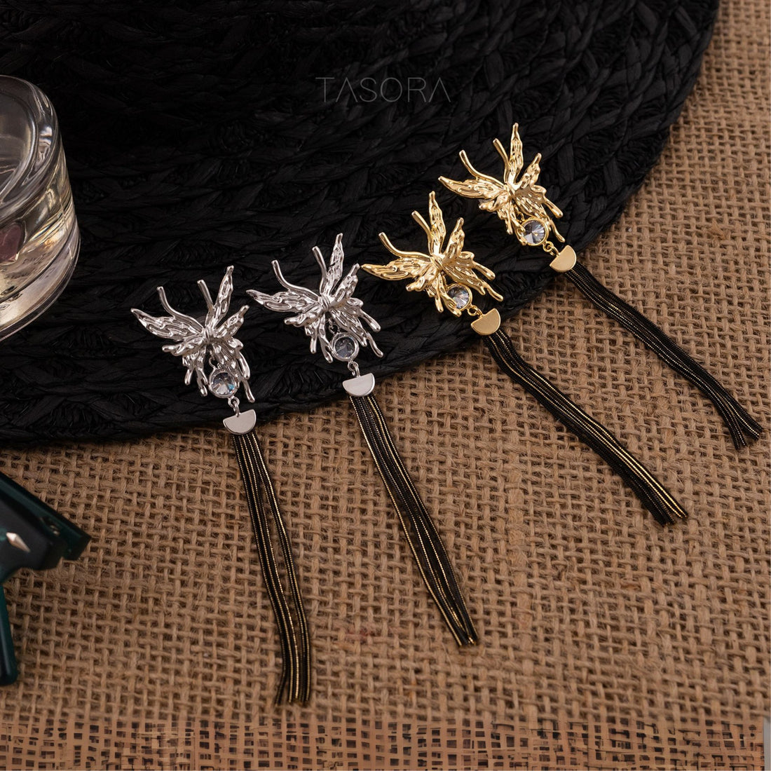 Zalfi Tassels Golden earrings with tassels on a textured surface, branded 'TASORA'.