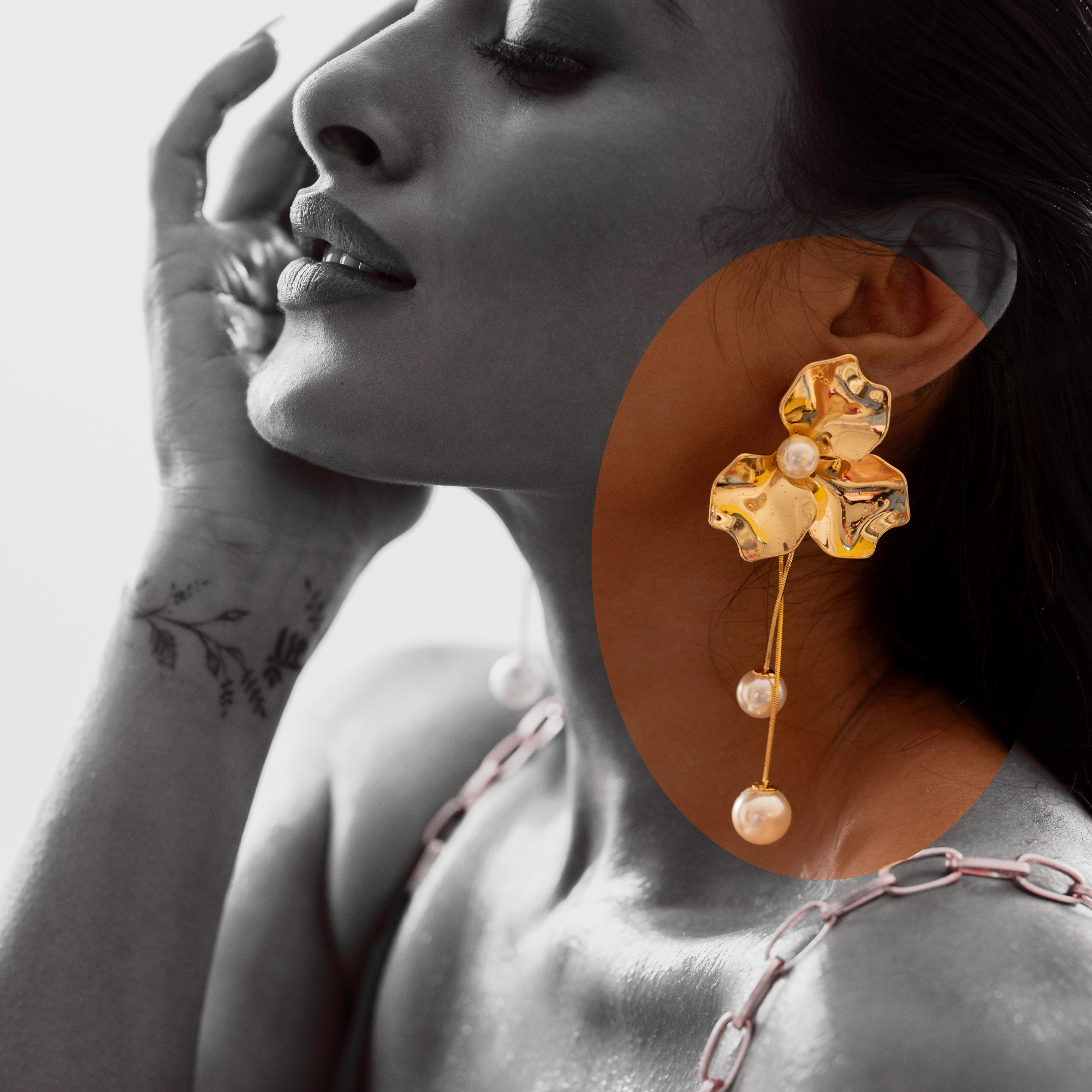 Close-up of a woman wearing a TASORA golden earring with pearls, with a focus on the earring.