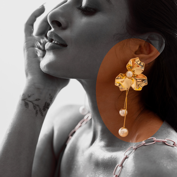 Close-up of a woman wearing a TASORA golden earring with pearls, with a focus on the earring.